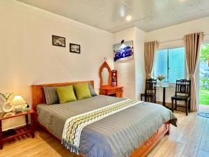 a bedroom with a bed and a table and chairs at Tiami Eden Villa - Nghỉ Dưỡng Sân Vườn Ven Biển in Vung Tau