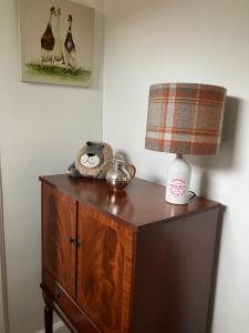a lamp on top of a dresser with a lamp on it at Wee Lyon Cottage Maybole 2 Bedroom Sleeps 4 in Maybole +11 photos