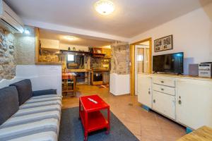 a living room with a couch and a tv at Holiday apartment WATERFRONT by the sea in Klimno