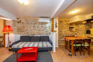 a living room with a bed and a table and a desk at Holiday apartment WATERFRONT by the sea in Klimno