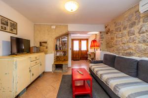 a living room with a couch and a tv at Holiday apartment WATERFRONT by the sea in Klimno