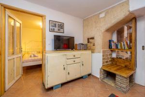 a room with a tv and a dresser with a tv at Holiday apartment WATERFRONT by the sea in Klimno +15 photos