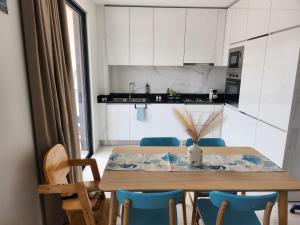a kitchen with a wooden table and blue chairs at Boa Mindelo Azul in Mindelo +19 photos