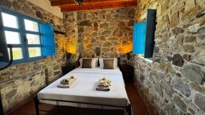 a bedroom with a bed in a stone wall at LITHONIA by Casa di Somnia in Asfendioú +15 photos