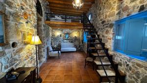 a room with a staircase in a stone wall at LITHONIA by Casa di Somnia in Asfendioú