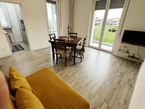 a living room with a couch and a table and chairs at Appartamento con terrazza in Gazzada
