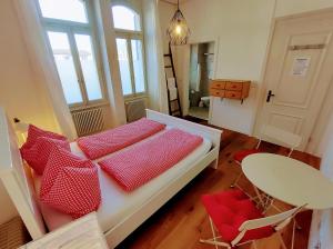 a bedroom with a bed with red pillows and a table at Adventure Hostel Interlaken in Interlaken +160 photos