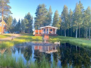a cabin in the middle of a pond with a house at Traditional Lapland 2BR House with Private sauna in Nuupas
