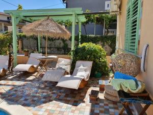 a patio with a bunch of chairs and an umbrella at Casa Rustica Ivano in Biograd na Moru