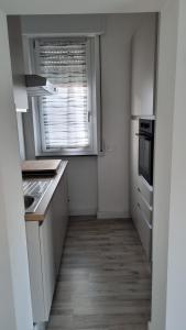 a kitchen with white cabinets and a window in it at Appartamento con terrazza in Gazzada
