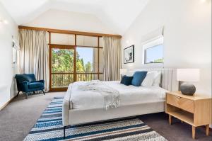 a white bedroom with a large bed and a window at Hobart Heritage Home - Close to CBD & Airport in New Town