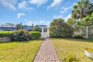 a garden with a gate and a brick pathway at Sleeps 24 Waterfront Dock Golf Cart Walk to Beach in Pawleys Island