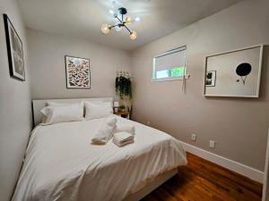Un dormitorio con una cama con sábanas blancas y una ventana. en 4BR house in trendy East Austin, en Austin