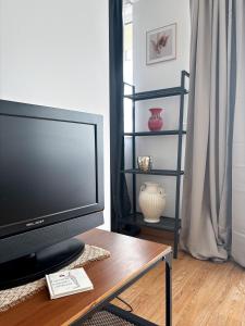 une télévision posée sur une table dans un salon dans l'établissement Viva La Vida By Iulius Mall, à Someşeni