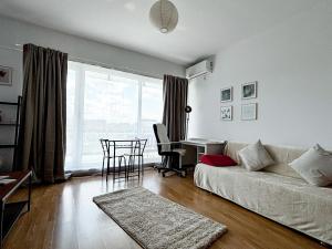 un salon avec un canapé, une table et un bureau dans l'établissement Viva La Vida By Iulius Mall, à Someşeni