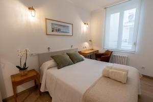 a bedroom with a large white bed and a window at Suite Haus Castelar in Santander