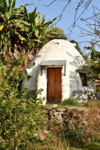 ポカラにあるHIMALAYAN AAMA APARTMENTの丘の上にある木製のドアが付いた小さなドームハウス