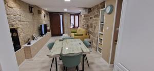 a room with a table and chairs and a tv at Abacería in Allariz