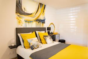 a bedroom with a bed with yellow pillows at Aimeelie - spacieux T3 avec piscine, terrasse, idéal famille, calme et lumineux in Lamentin