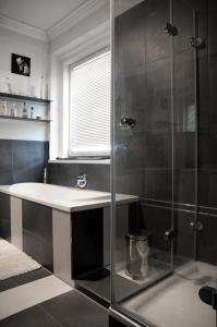 a bathroom with a glass shower and a sink at Pension Villa Maria in Karlovy Vary