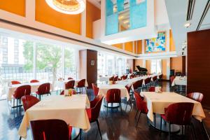 a restaurant with white tables and red chairs at Keisei Hotel Miramare in Chiba