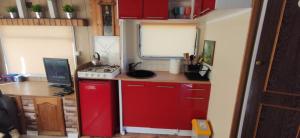 a small kitchen with a red refrigerator and a desk at Holenderka Artur in Stegers