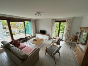 a living room with a couch and chairs and windows at Peppino II 0202 - 3 bedrooms 6p - penthouse sunny terraces in Sint-Idesbald