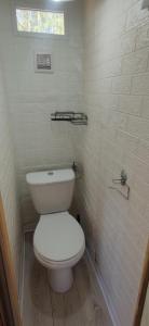 a bathroom with a white toilet and a window at Holenderka Artur in Stegers