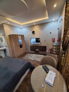 una camera da letto con un letto, un tavolo e una TV di استوديو ريفي تنومة a Tanomah