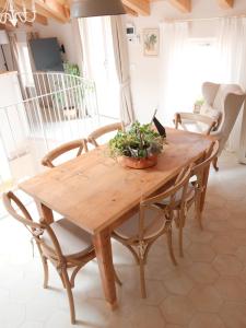 a wooden table with chairs and a potted plant on it at Lakeview Jonny house on the roofs in Lezzeno