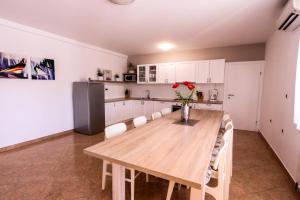 a kitchen with a wooden table and white cabinets at Villa Lavanda near Pazin, a modern pool villa in the heart of Istria in Pulići