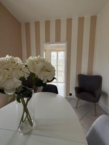 un vaso con fiori bianchi seduto su un tavolo di DooR48 a Novara