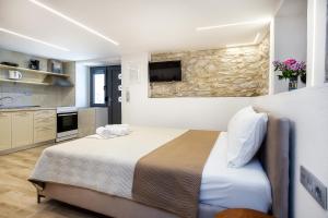 a bedroom with a bed and a tv on the wall at Theros Easy Living in Theológos