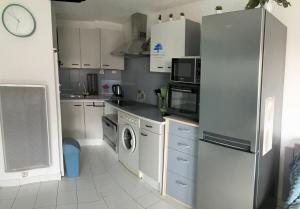una cocina con nevera y lavadora en Studio Bleu Riviera - Évasion en bord de mer, en Port-la-Nouvelle