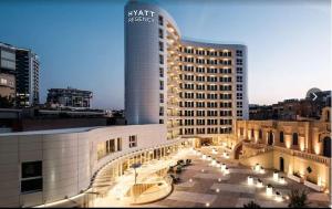 a large building in a city with a tall building at Paceville StJulians centre near Beach in Paceville