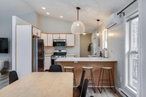 cocina con mesa, sillas y barra en Dunes & Waves Retreat - Perfect Lake Getaway, en Mears