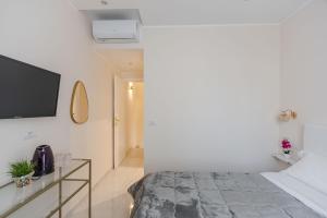 Un dormitorio con una cama y un televisor en una pared. en Ginevra Luxury Taormina by Wonderful Italy, en Taormina 14 fotos más