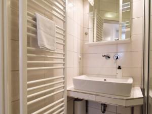 a white bathroom with a sink and a mirror at Altstadtapartment- Historischer Charme trifft modernen Komfort zentral & gemütlich mit Parkplatz! in Niederdorla +11 photos