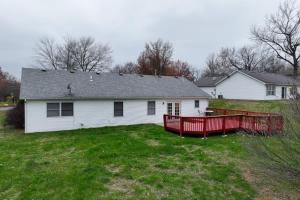 a white house with a red deck in a yard at Cozy Retreat 3bdrm 2bath house with deck in Columbia
