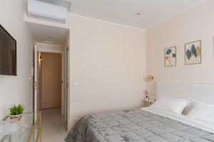 Un dormitorio blanco con una cama y un televisor. en Ginevra Luxury Taormina by Wonderful Italy, en Taormina