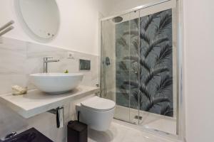 Un baño con lavabo, inodoro y ducha. en Ginevra Luxury Taormina by Wonderful Italy, en Taormina