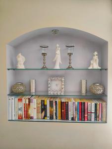 a book shelf with books and a clock on it at MAYA apartament in Jantar