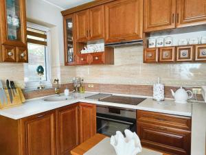 a kitchen with wooden cabinets and a sink at MAYA apartament in Jantar
