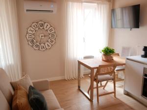 a living room with a table and a clock on the wall at La casa di Gio in Lezzeno