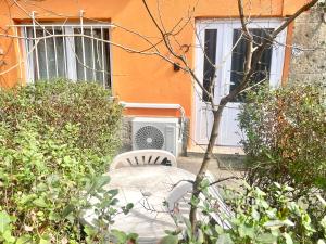 una sedia bianca seduta di fronte a una casa di Film Poster or Coffee Basement Apartman with terrace a Budapest