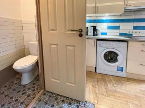 un bagno con WC e lavatrice di Film Poster or Coffee Basement Apartman with terrace a Budapest