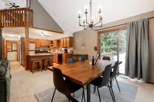 a kitchen and dining room with a wooden table and chairs at Majestic Escapes Hot Tub Firepit Deck Large Yard in Lake Ann