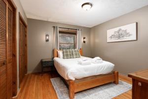 a bedroom with a bed and a window at Majestic Escapes Hot Tub Firepit Deck Large Yard in Lake Ann