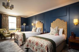 two beds in a room with blue walls at The Harbourview Hotel in Carnlough