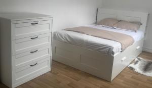 a bedroom with a bed with a white dresser at Appartement cozy proche de toutes commodités in Gagny
